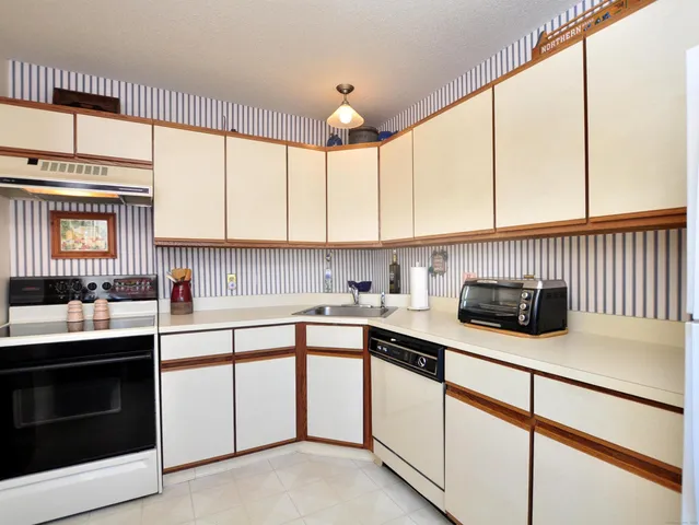 a kitchen with stainless steel appliances granite countertop a sink a stove and cabinets