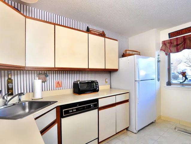 a kitchen with stainless steel appliances a sink a counter space and a window