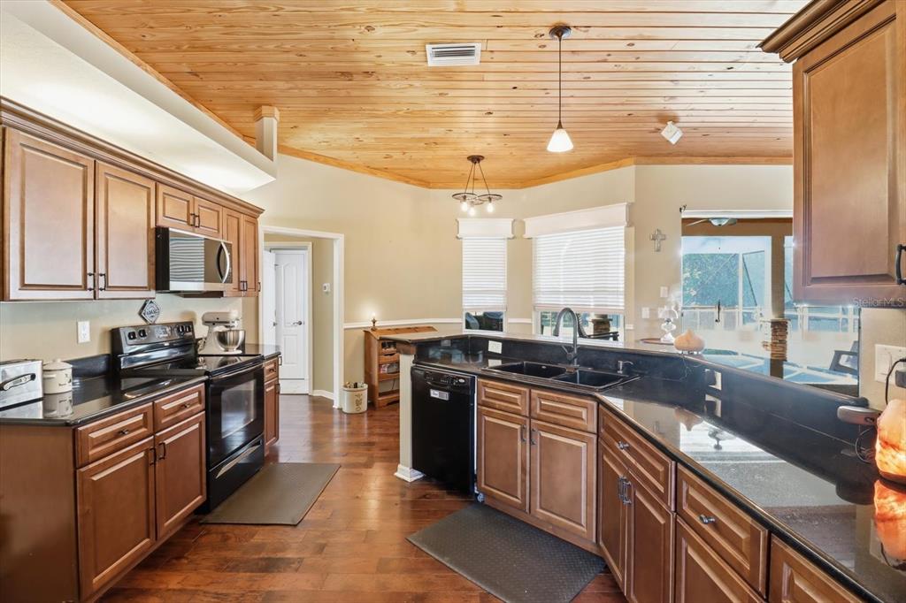3030 South Bay Berry Point Inverness, FL 34450 - Photo 12 of 45 a kitchen with stainless steel appliances granite countertop a stove a sink dishwasher and a microwave oven with cabinets