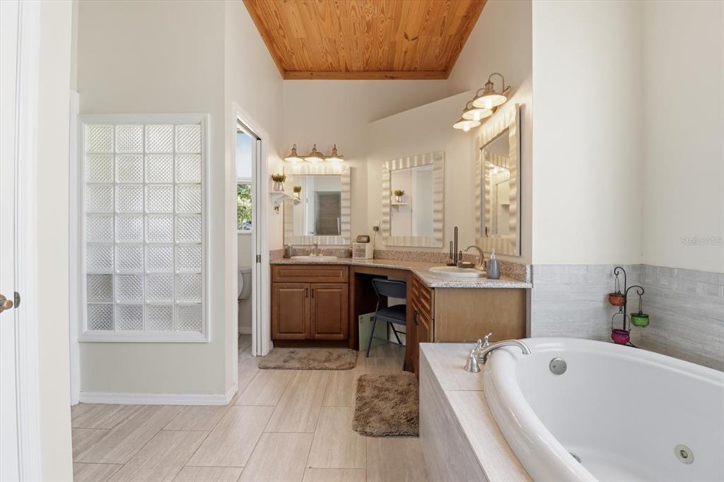 3030 South Bay Berry Point Inverness, FL 34450 - Photo 27 of 45 a bathroom with a tub a sink a mirror and a shower
