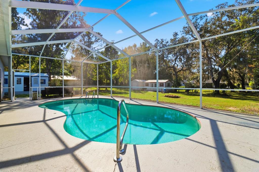 3030 South Bay Berry Point Inverness, FL 34450 - Photo 32 of 45 a view of a swimming pool with a bench and lawn chairs