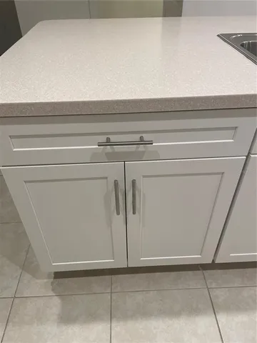 a kitchen with granite countertop white cabinets and stainless steel appliances