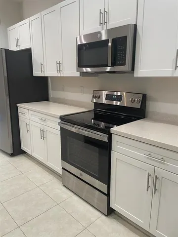 a view of empty room with window and refrigerator