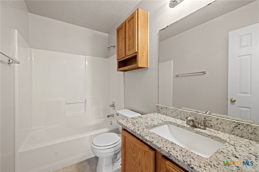 214 Timber Ridge Drive Nolanville, TX 76559 - Photo 23 of 31 a bathroom with a granite countertop sink toilet and a mirror
