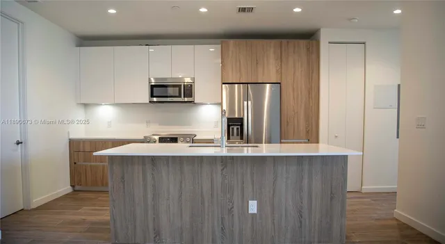 a kitchen with stainless steel appliances a sink stove and refrigerator