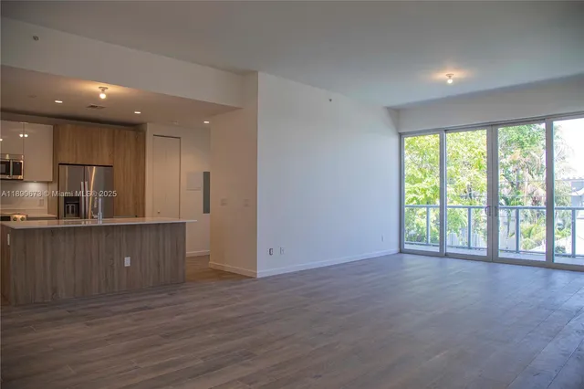 a view of a kitchen with wooden floor and a window