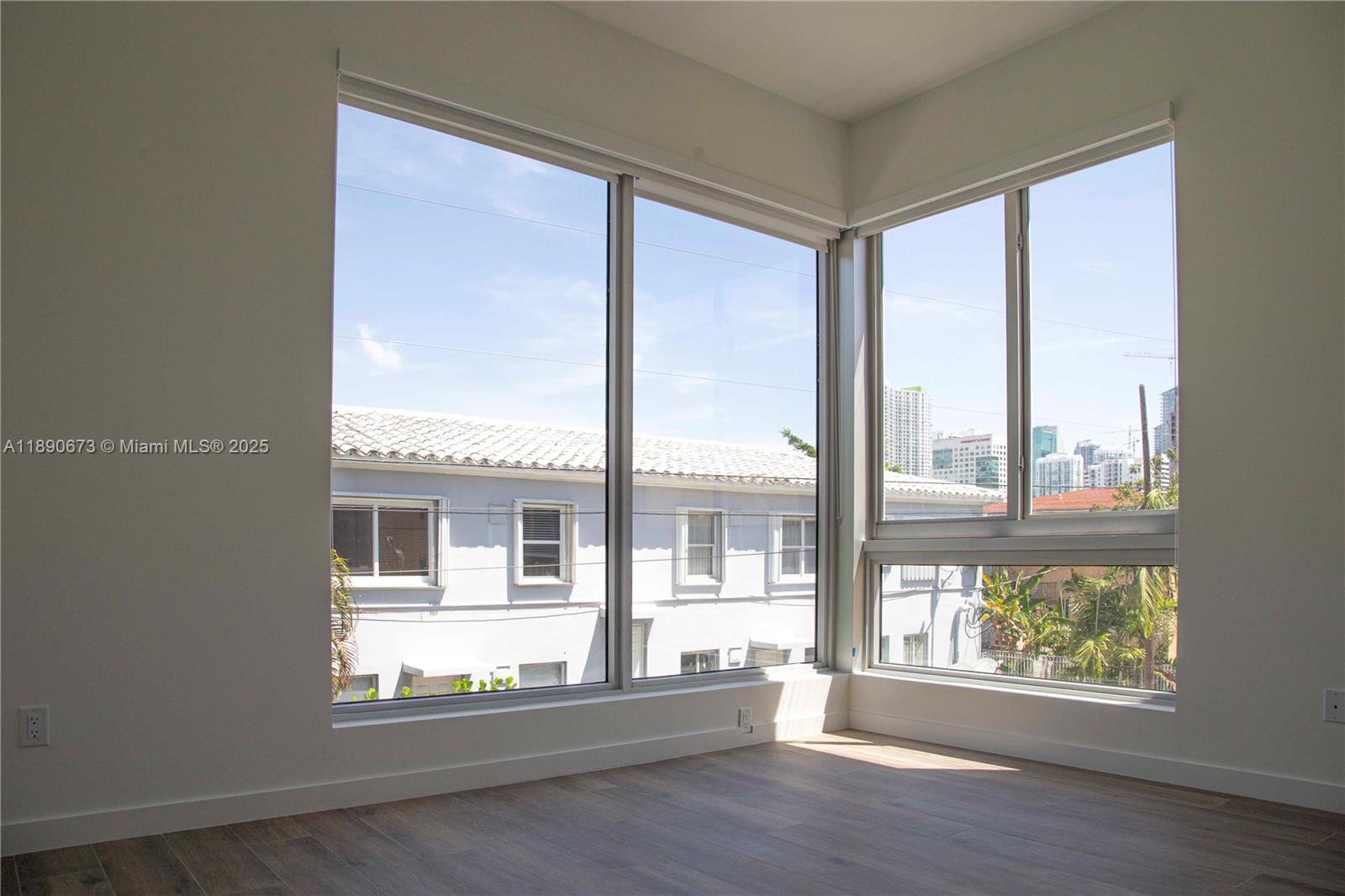 529 Southwest 11th Street, Unit 203 Miami, FL 33129 - Photo 9 of 24 an empty room with wooden floor and windows