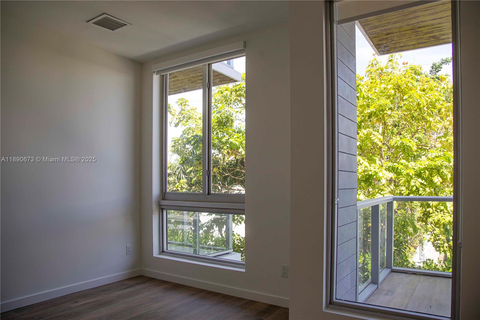 529 Southwest 11th Street, Unit 203 Miami, FL 33129 - Photo 10 of 24 a view of an empty room with wooden floor and a window