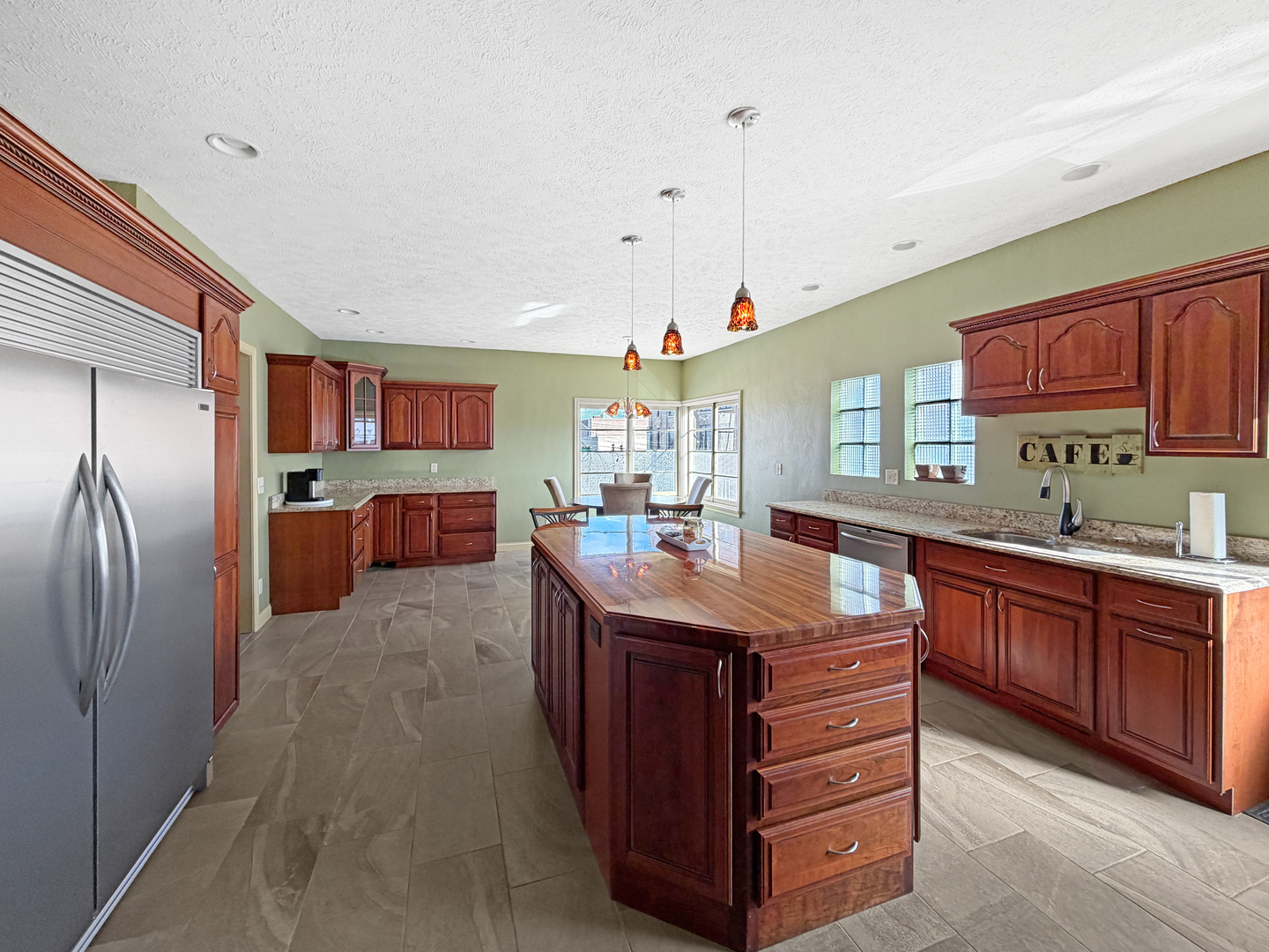 222 West Exchange Street Freeport, IL 61032 - Photo 11 of 46 a kitchen with stainless steel appliances kitchen island granite countertop a table chairs and a refrigerator