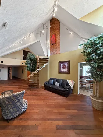 a kitchen with stainless steel appliances granite countertop a sink a stove a refrigerator cabinets and chairs