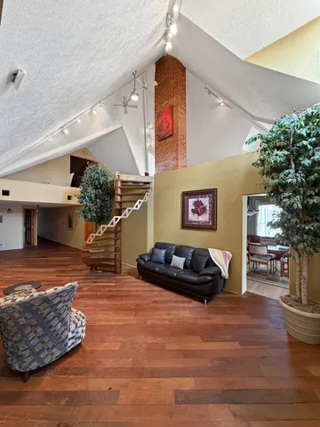 a kitchen with stainless steel appliances granite countertop a sink a stove a refrigerator cabinets and chairs