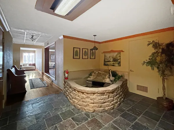 a living room with stainless steel appliances kitchen island granite countertop a refrigerator a sink dishwasher and a living room view