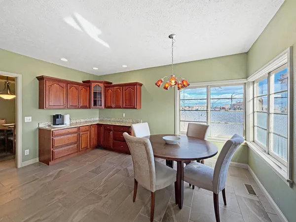 a kitchen with stainless steel appliances granite countertop a stove a sink dishwasher a refrigerator and a oven with wooden floor
