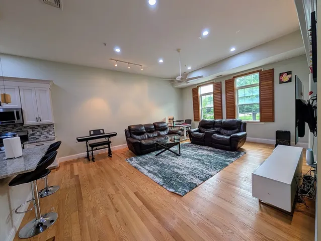 a living room with furniture and a wooden floor