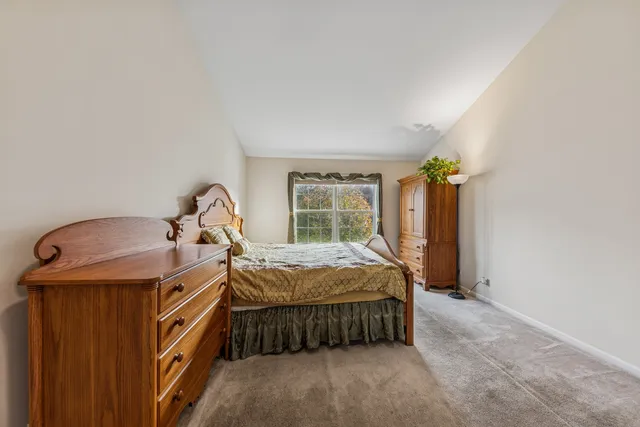 a bed sitting in a bedroom next to a window