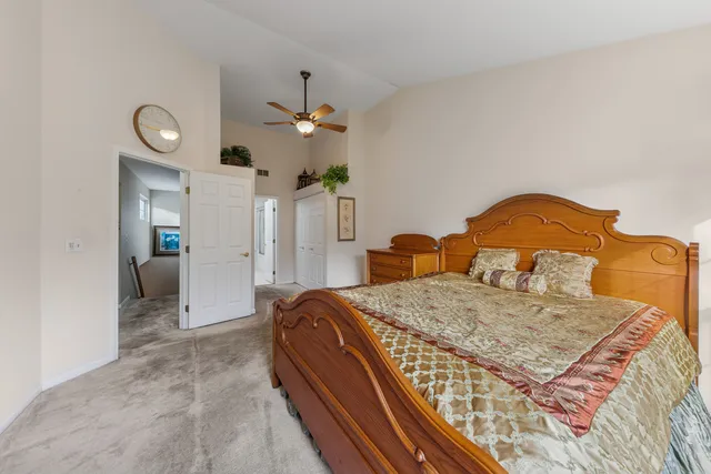 a bedroom with a bed chandelier and a view of kitchen