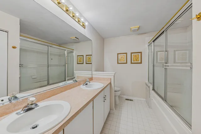 a bathroom with a double vanity sink mirror and shower