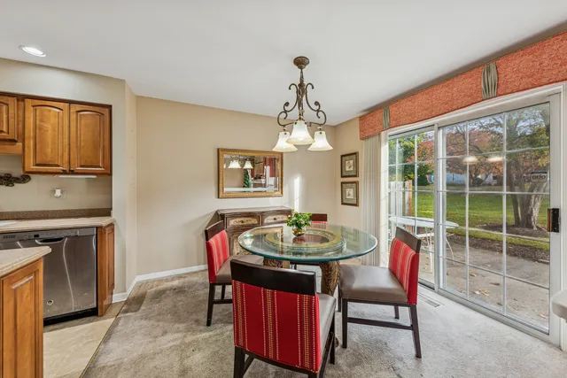a dining room with furniture a chandelier and window