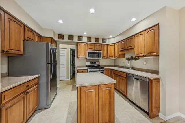 a kitchen with stainless steel appliances granite countertop a refrigerator stove and sink