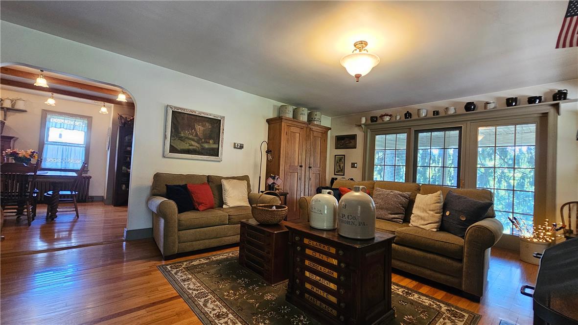 585 Buttermilk Road Hellertown, PA 18055 - Photo 7 of 82 Rich hardwood flooring extends throughout this well-lit living area, offering a seamless flow into the adjacent dining space.