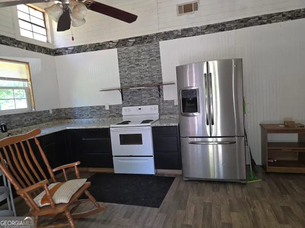 a kitchen with a refrigerator wooden floor and a fireplace