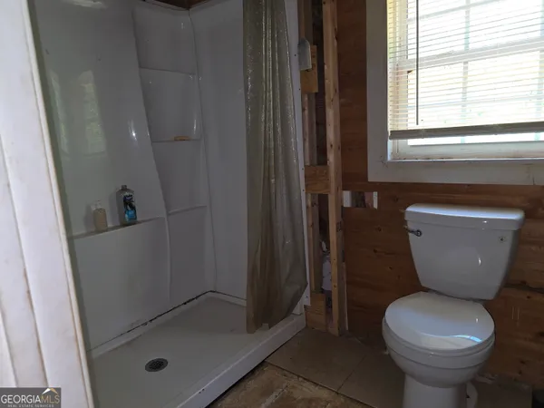 a bathroom with a toilet and a shower