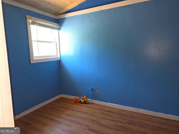 a view of a room with wooden floor and a window