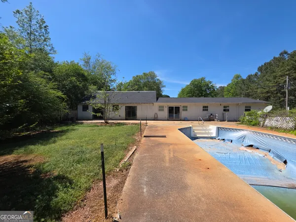 a swimming pool with outdoor seating and yard