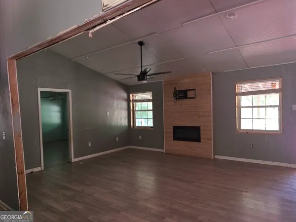 an empty room with windows and fireplace