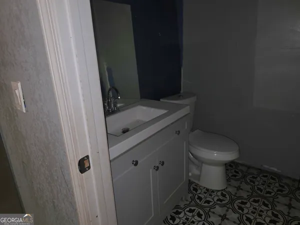 a bathroom with a granite countertop toilet and a sink