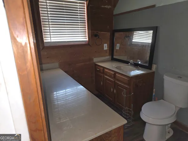 a bathroom with a toilet a sink and a window