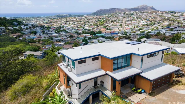 an aerial view of residential houses with yard and mountain view in back