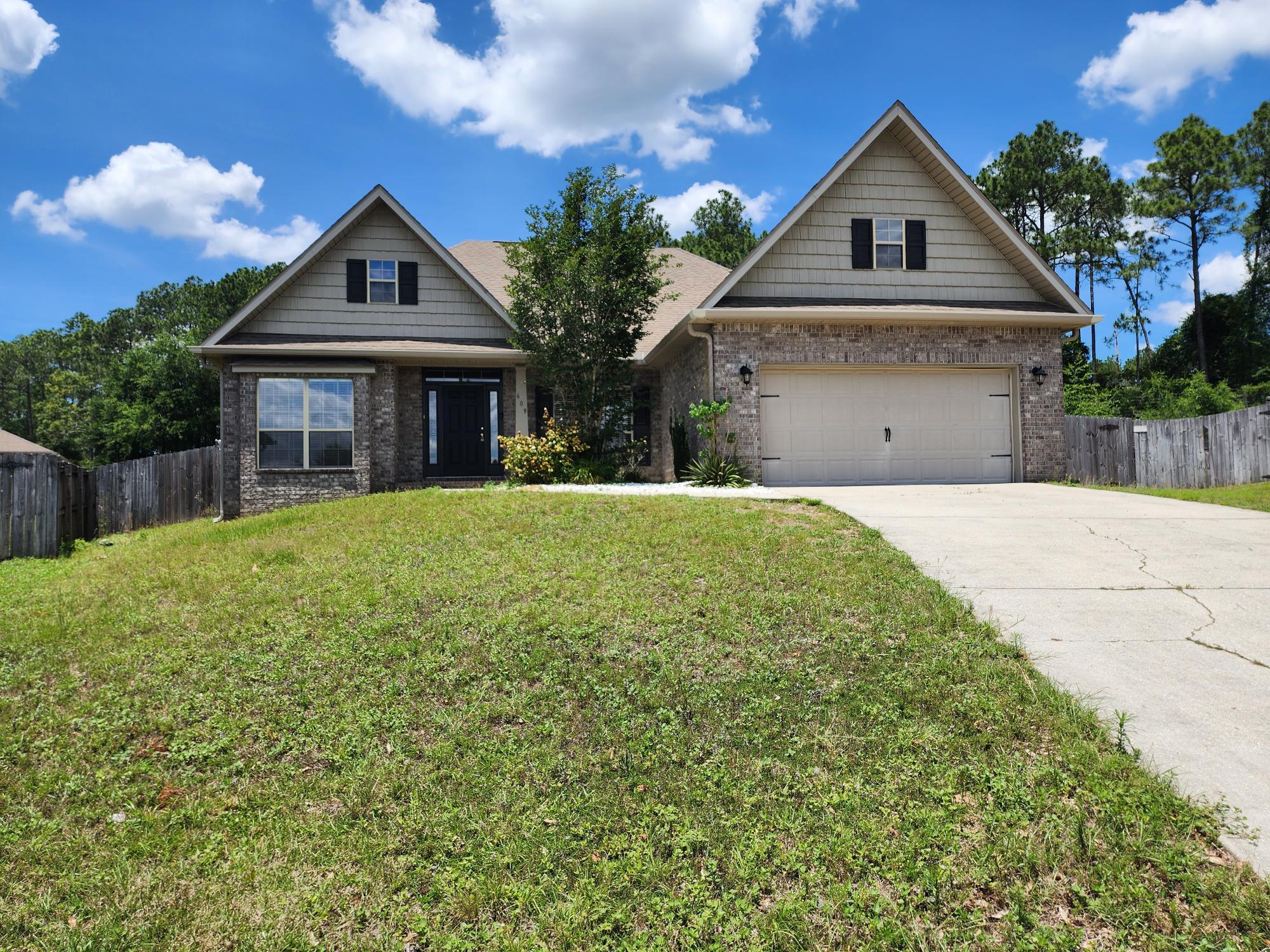 609 Rowan Circle Crestview, FL 32536 - Photo 1 of 37 a front view of a house with a yard and garage