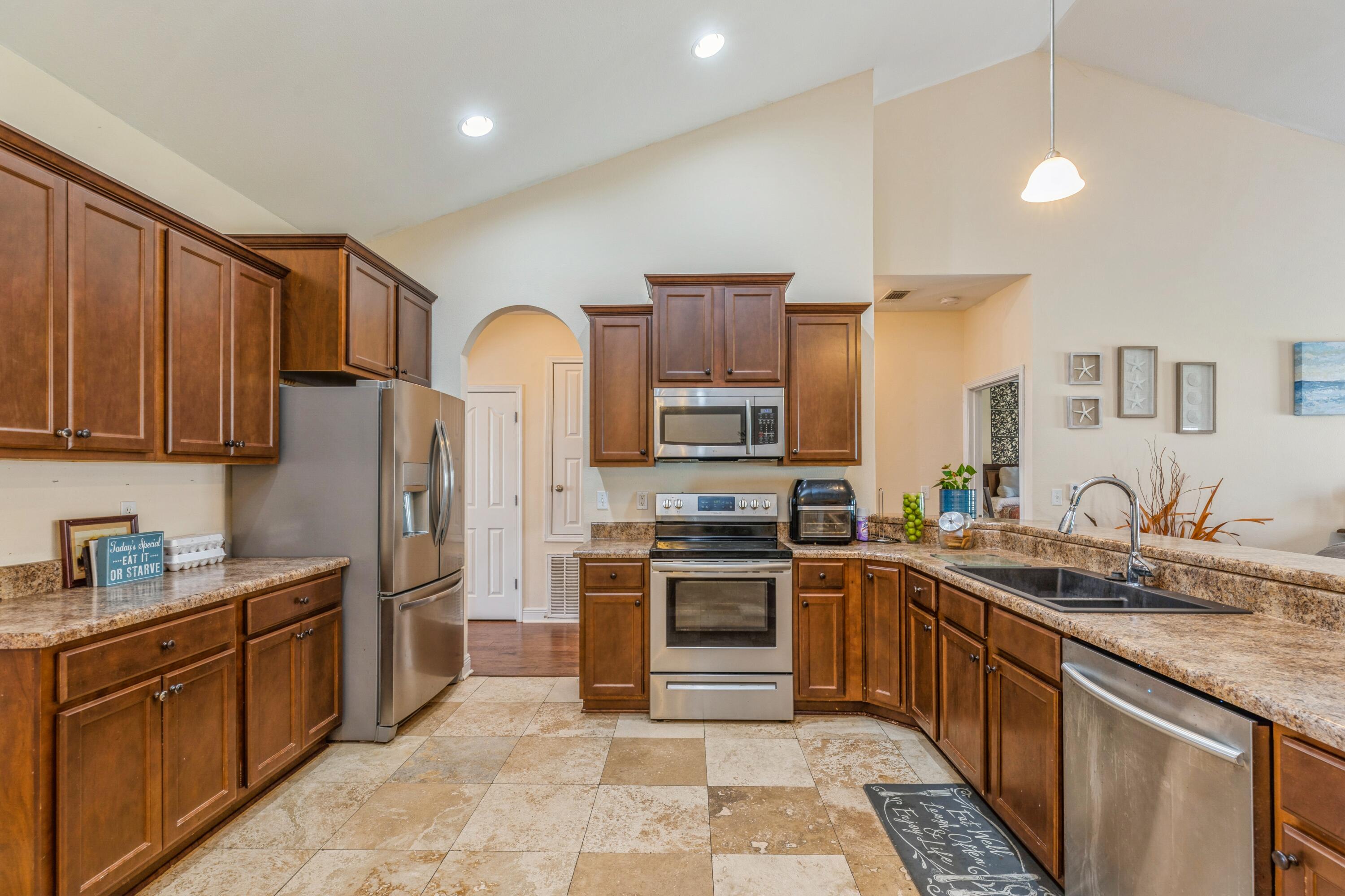 609 Rowan Circle Crestview, FL 32536 - Photo 17 of 37 a kitchen with stainless steel appliances granite countertop a sink stove and refrigerator
