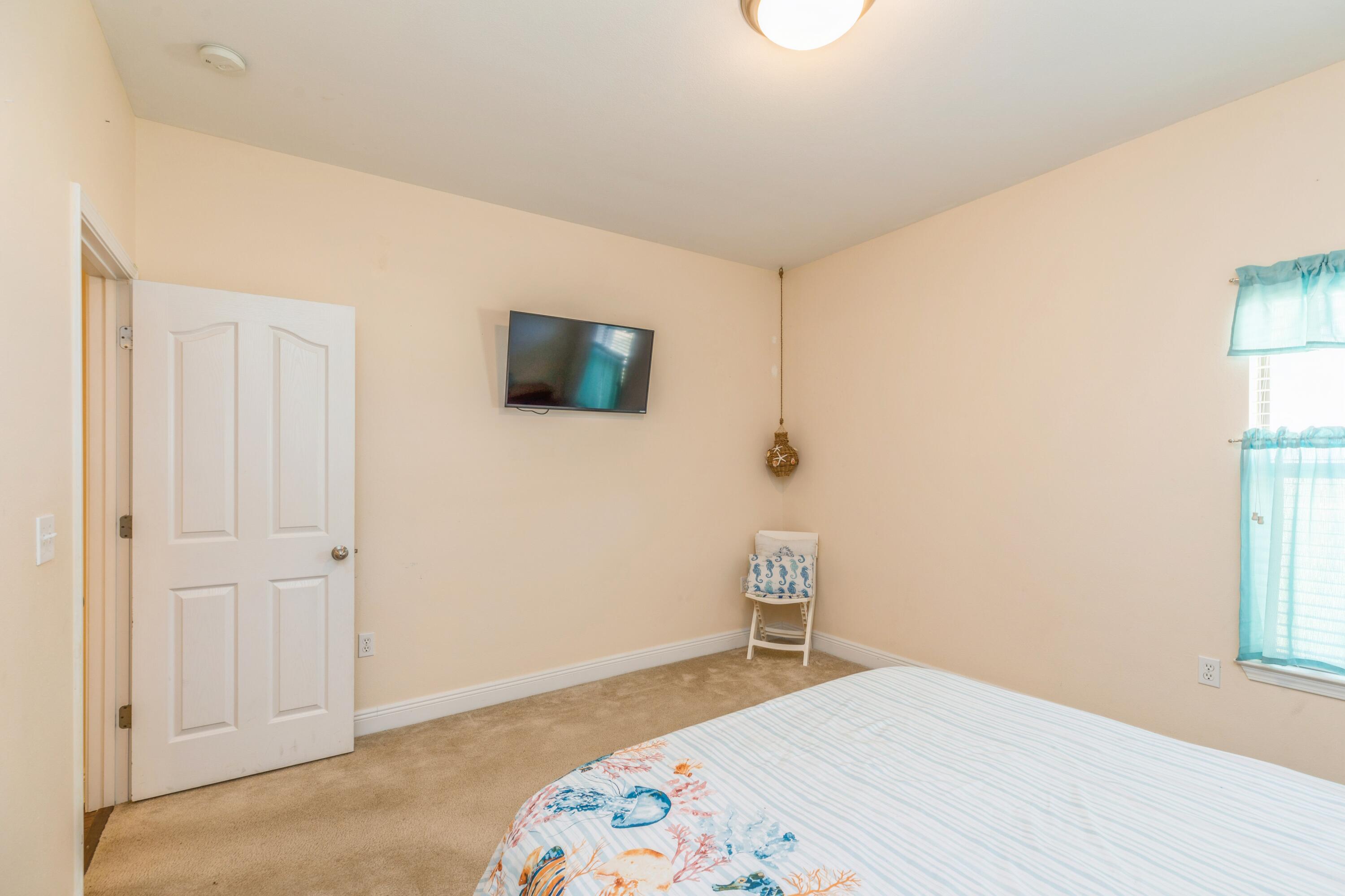 609 Rowan Circle Crestview, FL 32536 - Photo 24 of 37 a bedroom with a bed and a flat screen tv