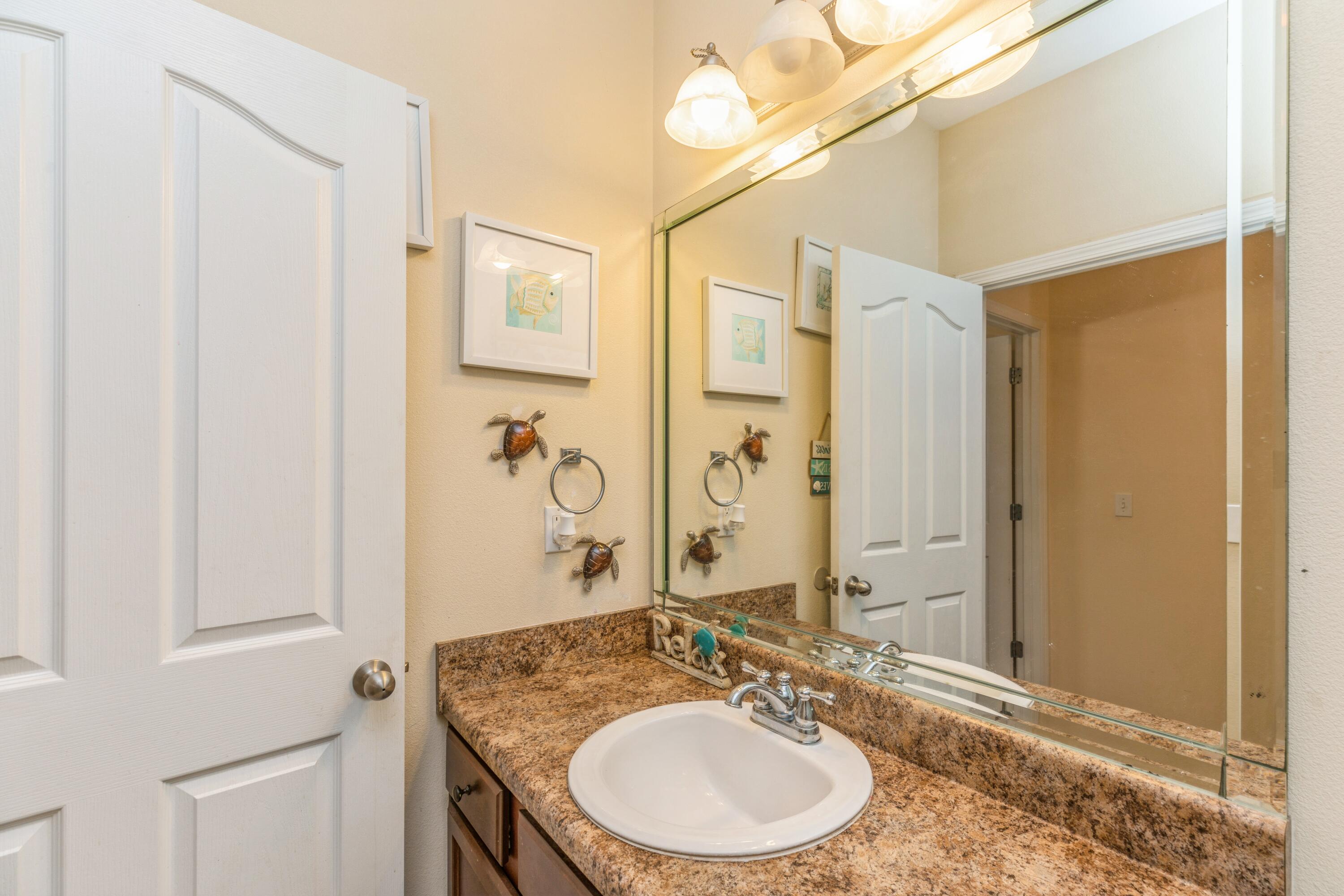 609 Rowan Circle Crestview, FL 32536 - Photo 26 of 37 a bathroom with a granite countertop sink a mirror and a shower