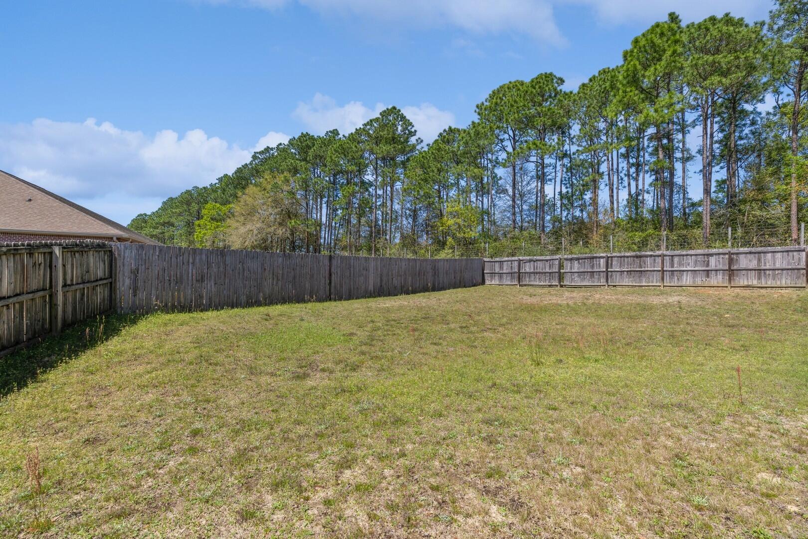 609 Rowan Circle Crestview, FL 32536 - Photo 34 of 37 a view of a backyard with large trees and wooden fence