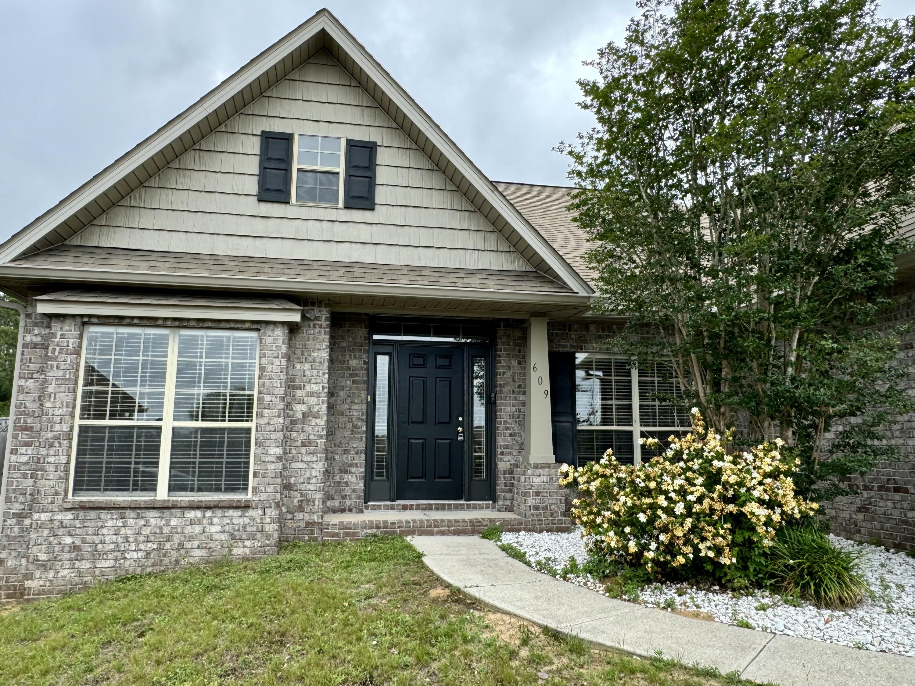 609 Rowan Circle Crestview, FL 32536 - Photo 5 of 37 a front view of a house with a garden