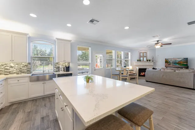 a large kitchen with kitchen island a large counter top space a sink stainless steel appliances and cabinets