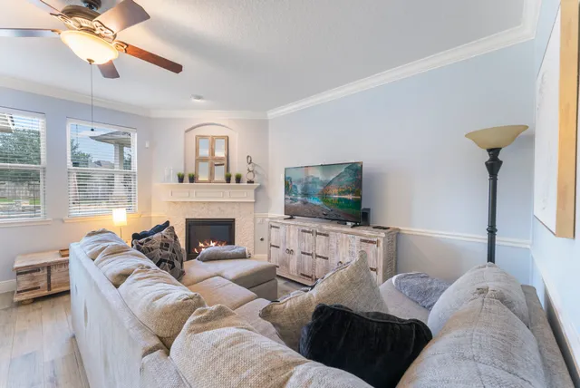 a living room with furniture a fireplace and a flat screen tv