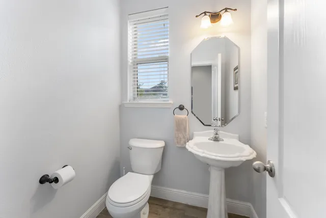 a bathroom with a toilet sink and mirror