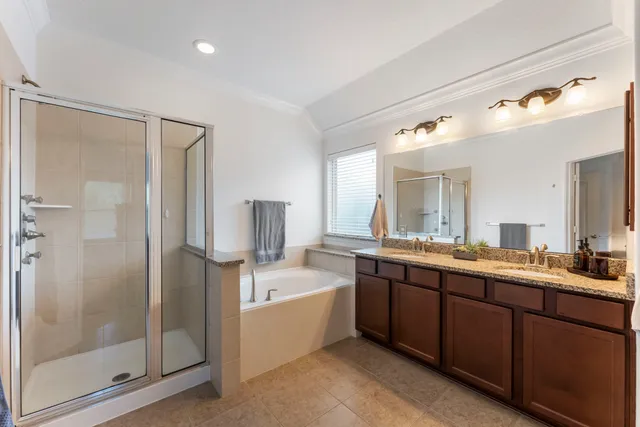 a bathroom with a tub sink shower and mirror