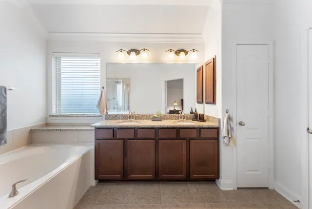 a bathroom with a granite countertop sink and a bathtub