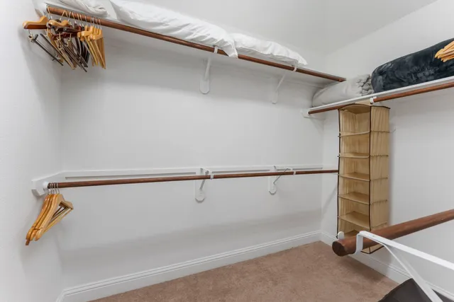 a view of walk in closet with clothes and shoes