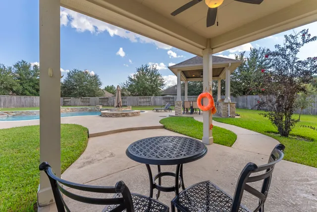 a view of a patio with a table chairs and a yard