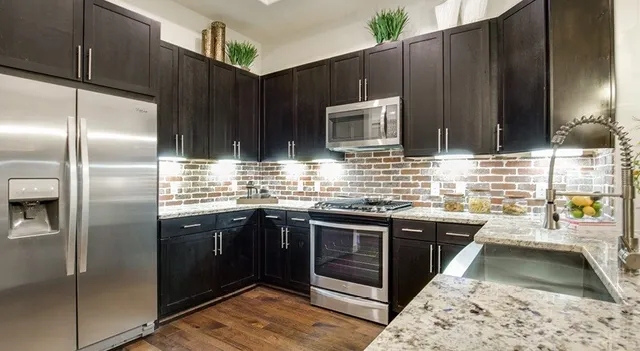 a kitchen with stainless steel appliances granite countertop a stove and a refrigerator