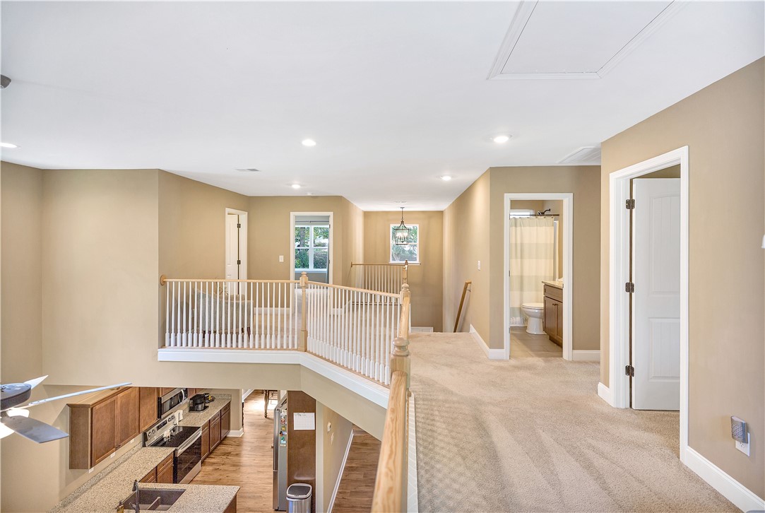 3004 Cobbs Way Anderson, SC 29621 - Photo 21 of 46 An open upper level features carpeted hallways, wooden railings, and views of the downstairs kitchen.