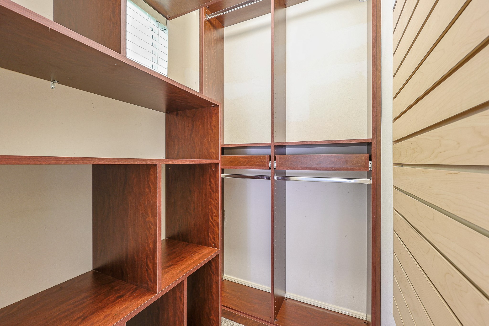 10306 Rudolph Court Missouri City, TX 77459 - Photo 21 of 34 Elevate your storage expectations with this meticulously upgraded secondary walk-in closet, boasting a premium built-in organization system that maximizes every square inch. Features deep open storage cubbies ideal for folded clothing, bins or displaying accessories and multi-level hanging rods to dramatically increase wardrobe capacity.