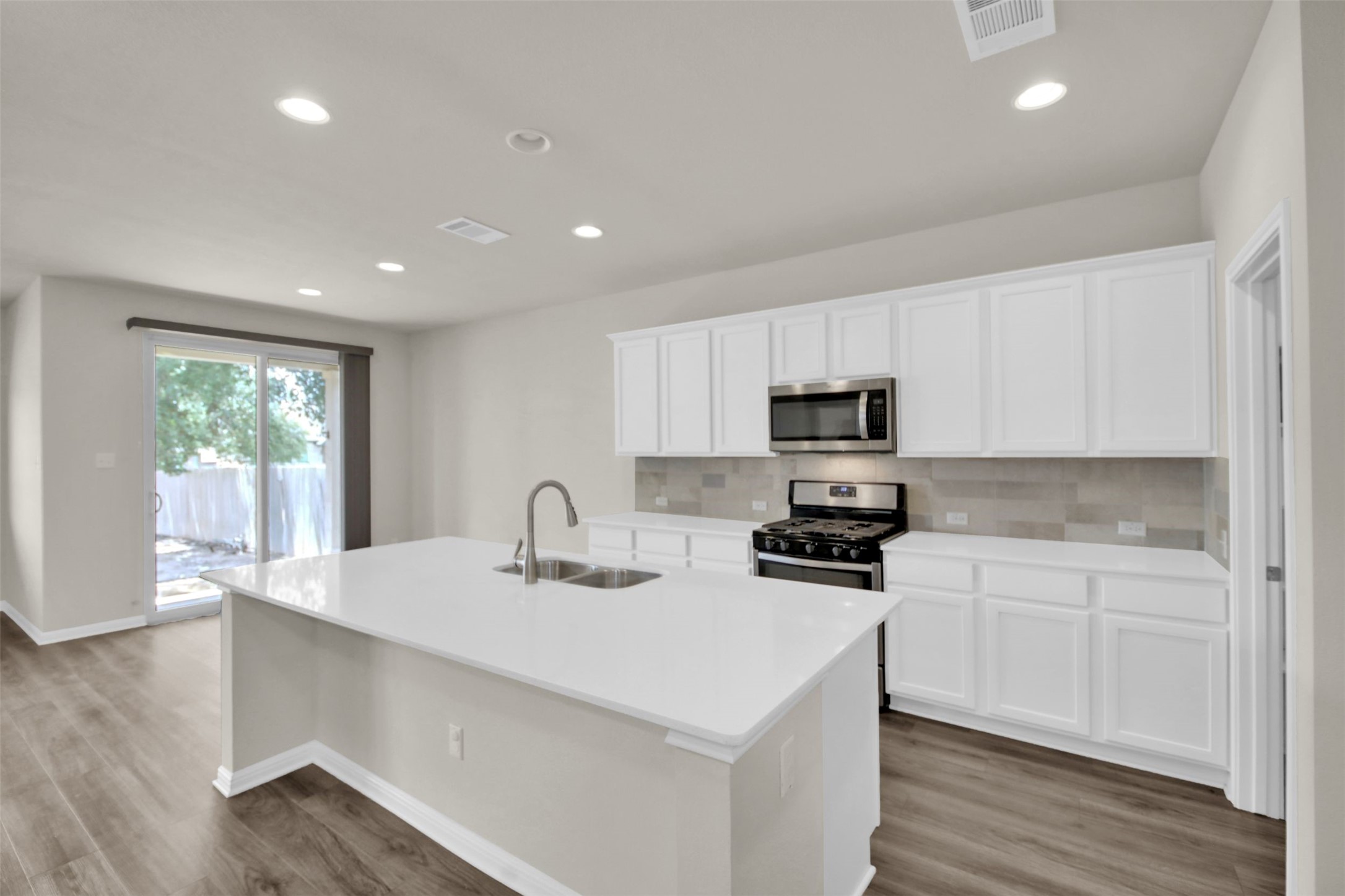 1829 Chickasaw Run Leander, TX 78641 - Photo 1 of 40 a kitchen with sink a microwave and cabinets