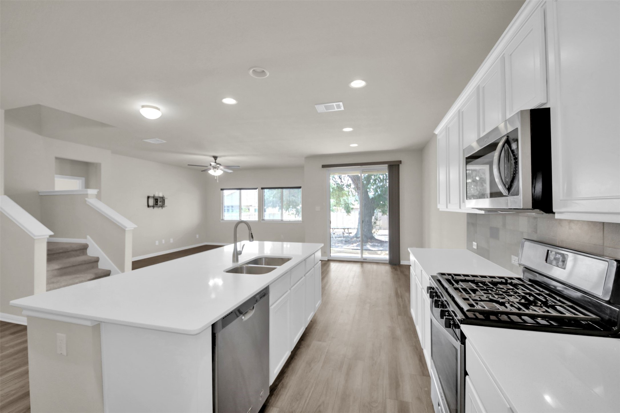 1829 Chickasaw Run Leander, TX 78641 - Photo 11 of 40 a kitchen with granite countertop a sink stove and cabinets